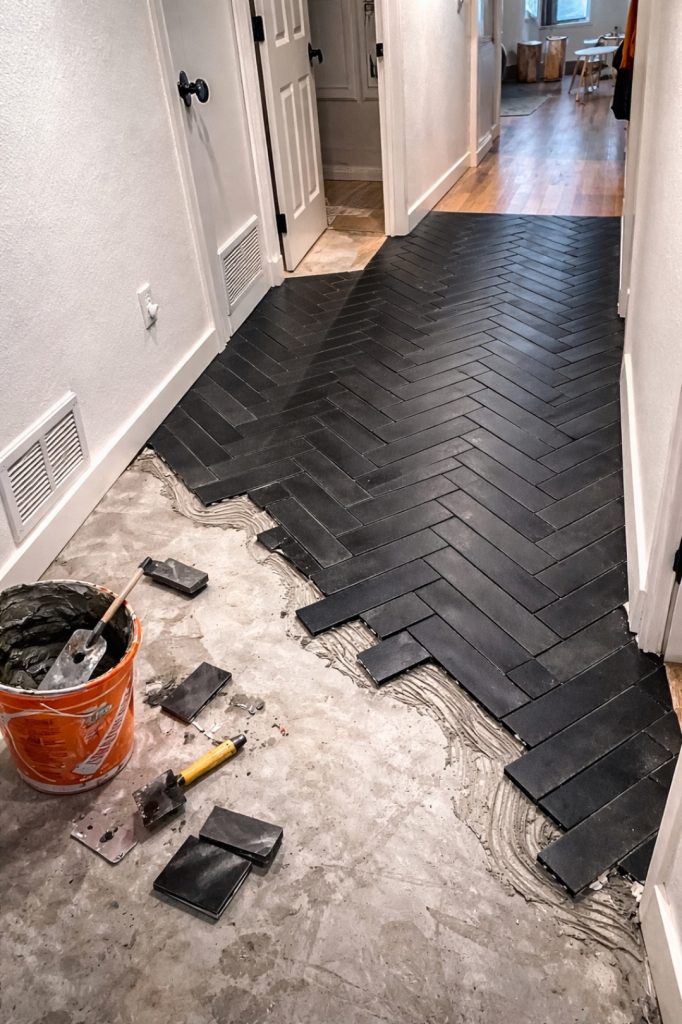 Black herringbone tile installation in progress by professional tile installer in Austin TX residential project