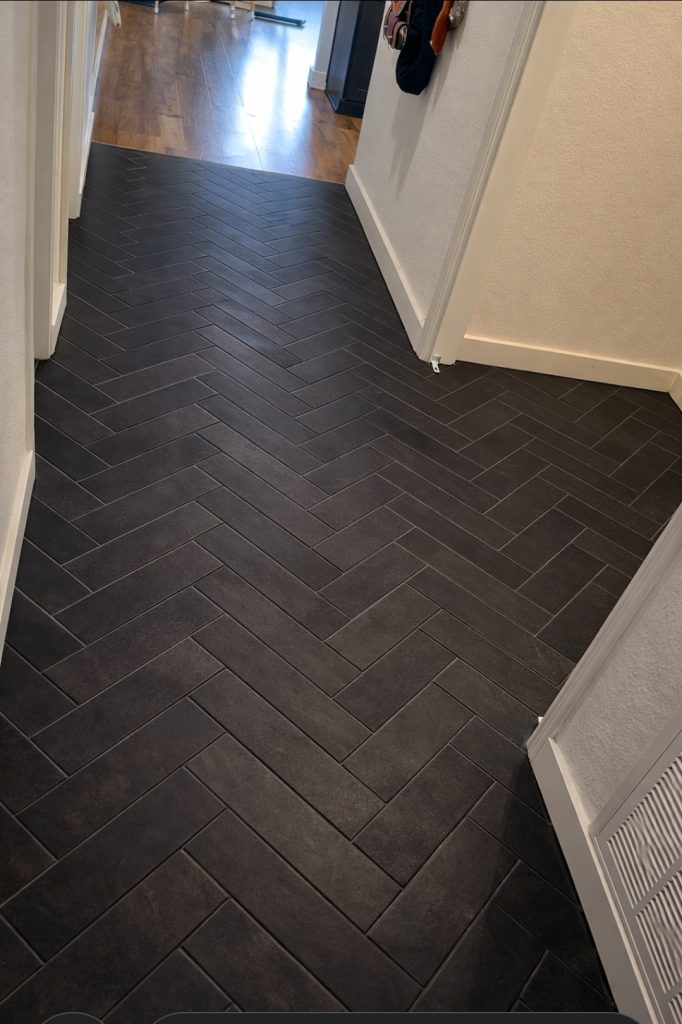 completed black herringbone tile floor installation in residential hallway in Austin TX 